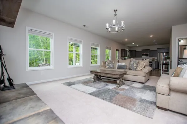 a living room with furniture and a chandelier