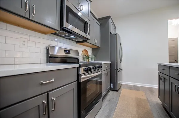 a kitchen with stainless steel appliances a sink a stove a microwave and cabinets
