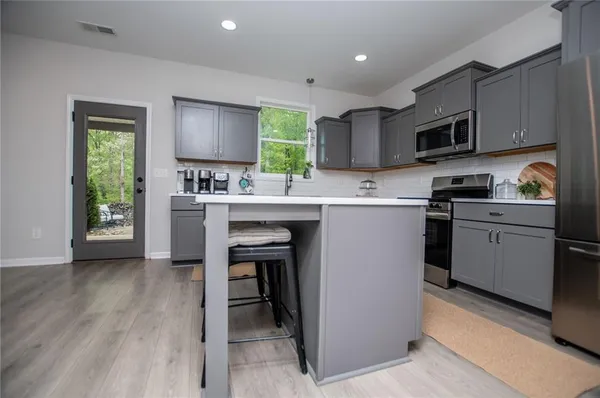 a kitchen with a sink appliances cabinets and a window