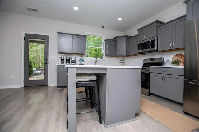 a kitchen with a sink appliances cabinets and a window