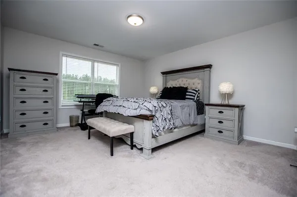 a spacious bedroom with a bed and a window