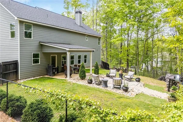 a view of a house with a patio and a yard