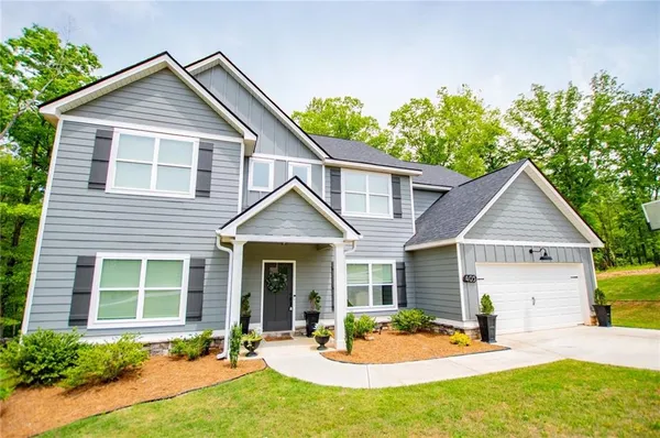 a front view of a house with glass windows and flowers