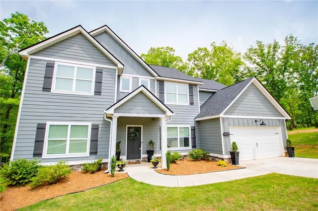 a front view of a house with glass windows and flowers