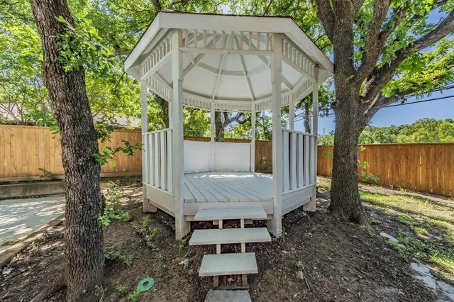 a view of backyard with a barn and a large tree
