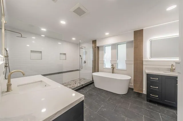 a spacious bathroom with a double vanity sink tub and mirror