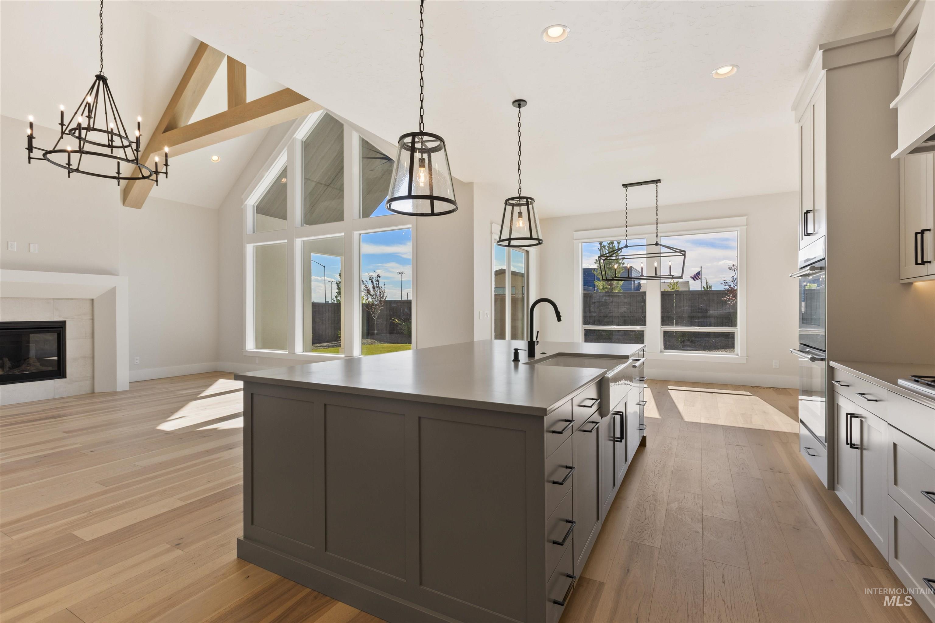 5857 South Highmark Avenue Meridian, ID 83642 - Photo 37 of 37 Kitchen featuring a chandelier, light wood-style flooring, an island with sink, open floor plan, and recessed lighting