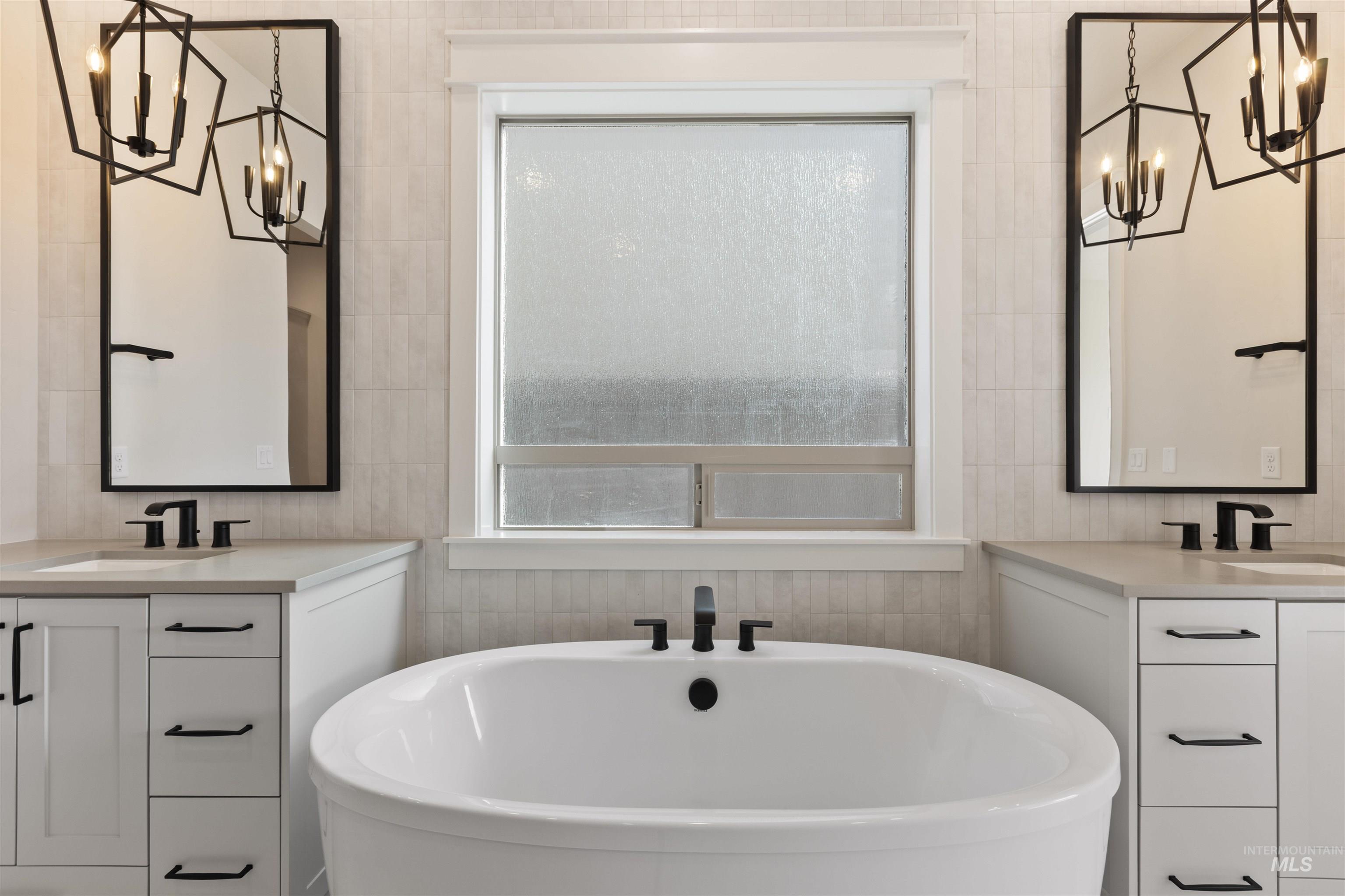 5857 South Highmark Avenue Meridian, ID 83642 - Photo 18 of 37 Full bath featuring a chandelier, a freestanding bath, and two vanities