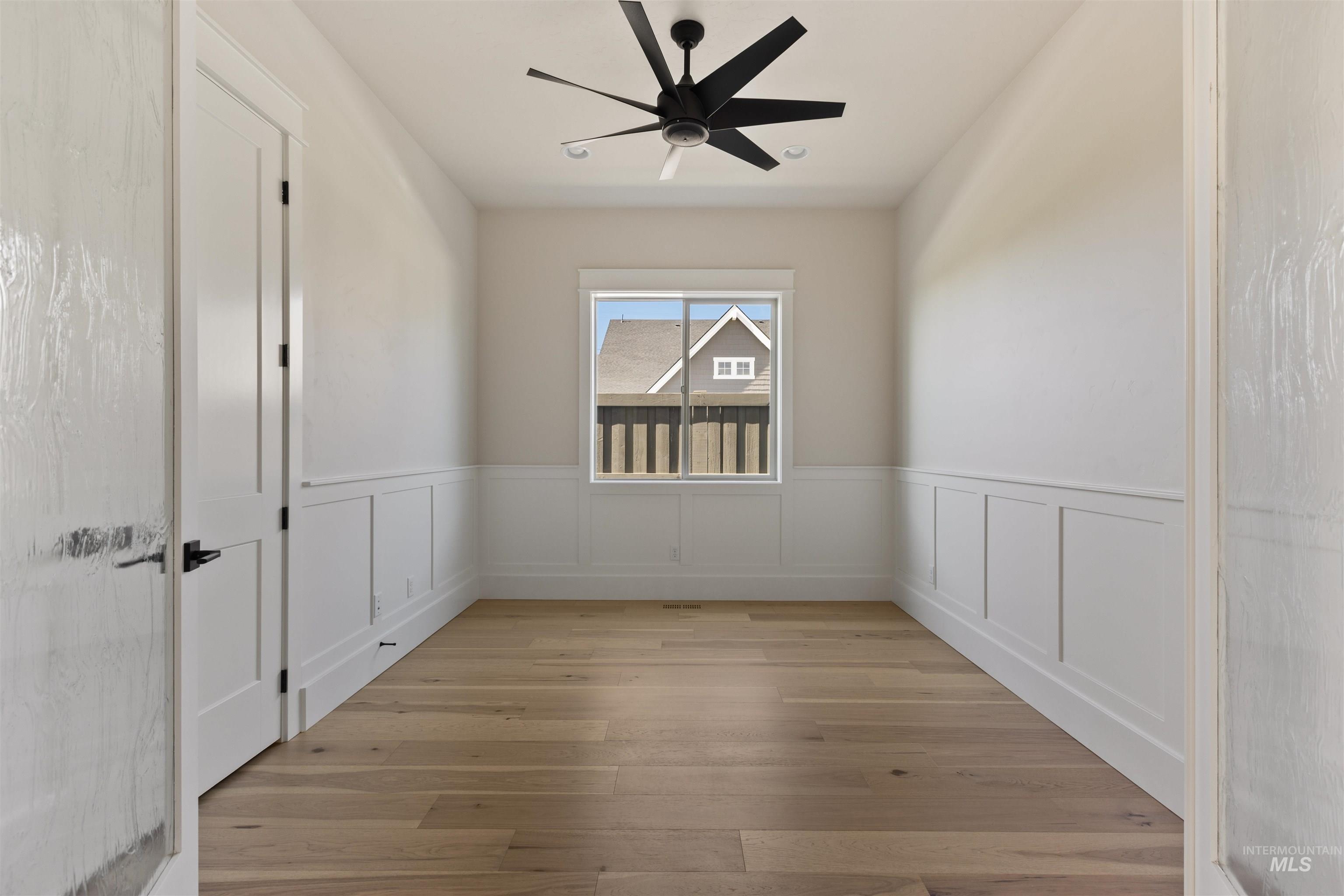 5857 South Highmark Avenue Meridian, ID 83642 - Photo 31 of 37 Unfurnished room with a wainscoted wall, light wood-style flooring, and ceiling fan