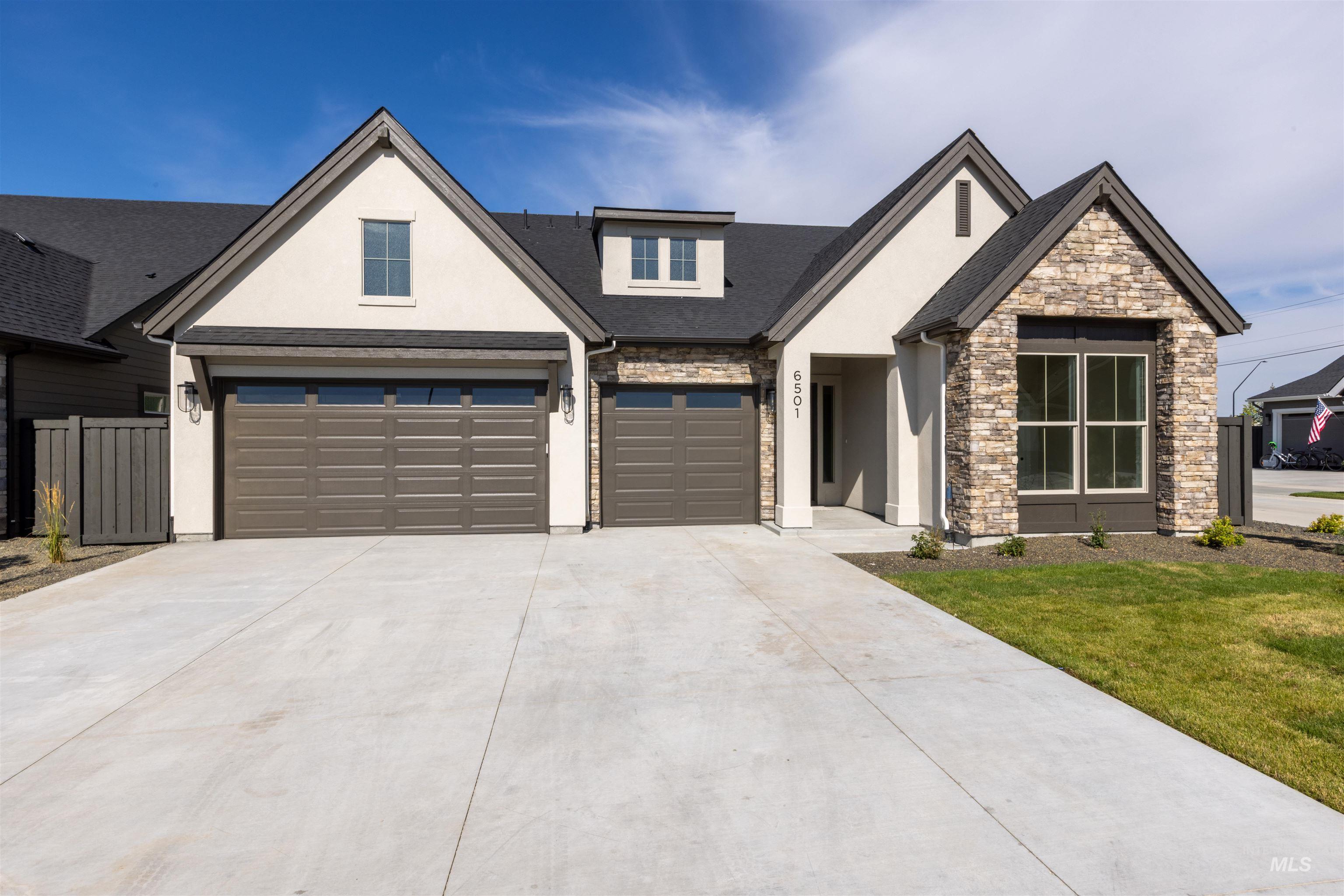 5857 South Highmark Avenue Meridian, ID 83642 - Photo 35 of 37 View of front facade featuring stucco siding, concrete driveway, an attached garage, stone siding, and a front lawn