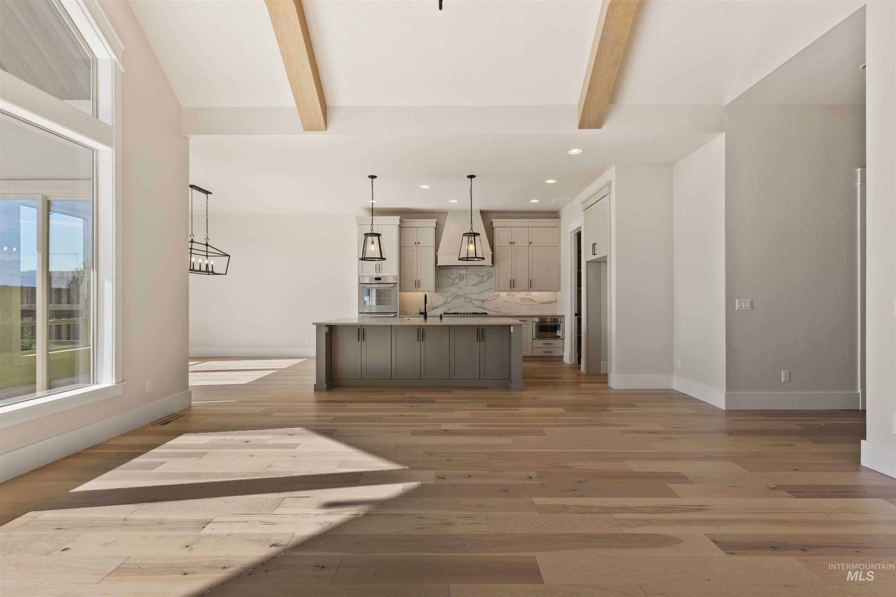 5857 South Highmark Avenue Meridian, ID 83642 - Photo 6 of 37 Kitchen featuring recessed lighting, backsplash, light wood finished floors, oven, and a center island with sink