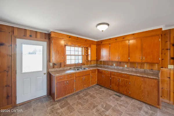 a large kitchen with a sink and large window