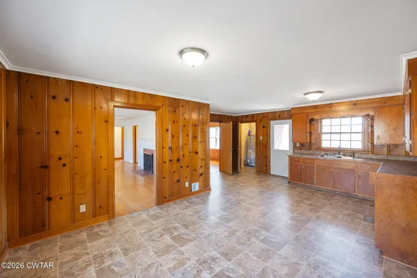 a living room with stainless steel appliances kitchen island granite countertop a refrigerator and a sink