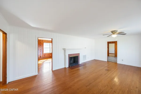 a view of empty room with wooden floor and fireplace