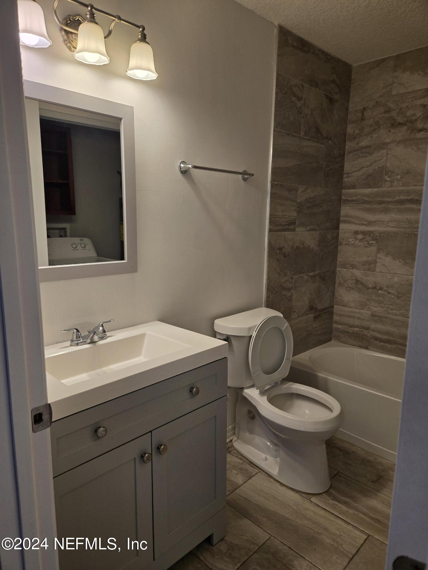 1055 Stocks Street Atlantic Beach, FL 32233 - Photo 11 of 15 a bathroom with a granite countertop toilet a sink and mirror