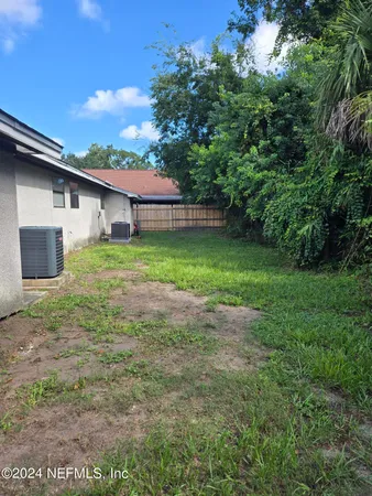 a backyard of a house with plants and a garden