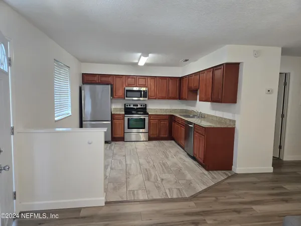 a kitchen with stainless steel appliances granite countertop a stove a sink and a refrigerator