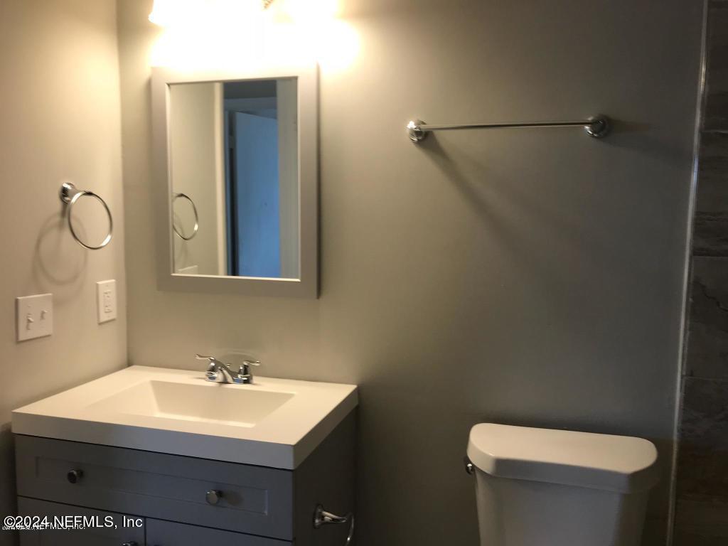 1055 Stocks Street Atlantic Beach, FL 32233 - Photo 10 of 15 a bathroom with a toilet a sink and mirror