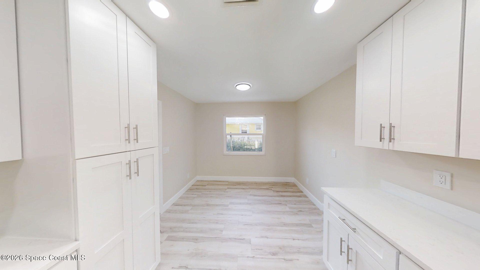 137 Concha Drive Sebastian, FL 32958 - Photo 11 of 29 a view of a kitchen with white cabinets and wooden floor