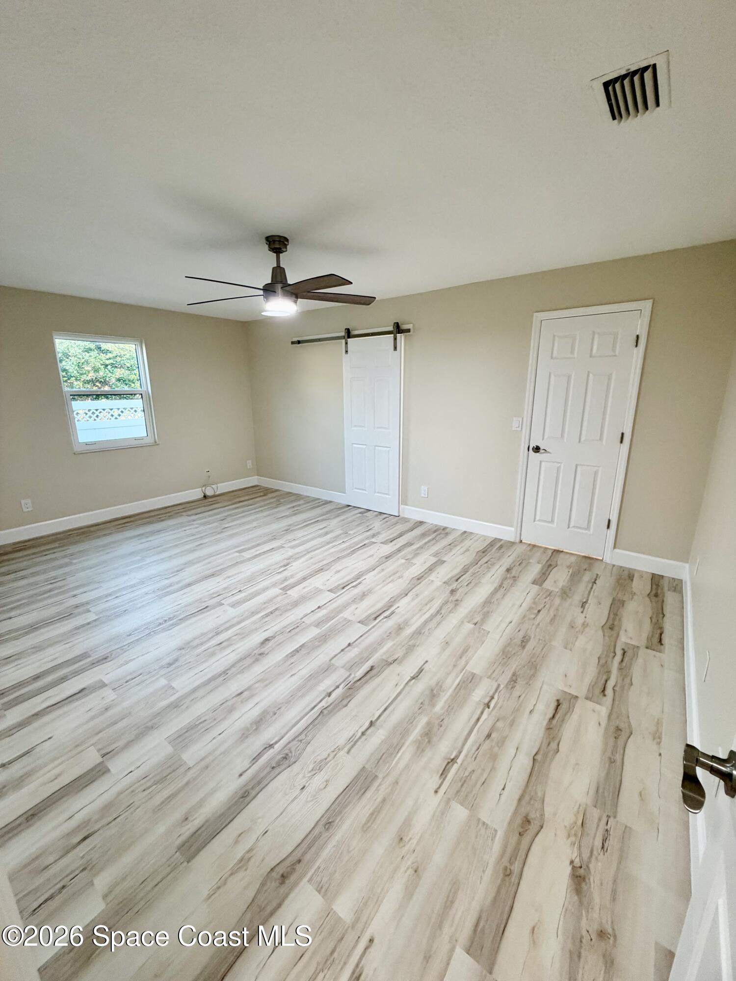137 Concha Drive Sebastian, FL 32958 - Photo 15 of 29 an empty room with wooden floor chandelier fan and windows
