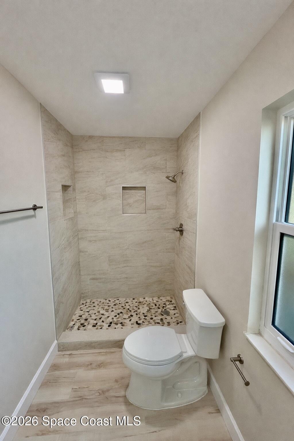 137 Concha Drive Sebastian, FL 32958 - Photo 18 of 29 a white toilet sitting next to a bathroom sink and a shower