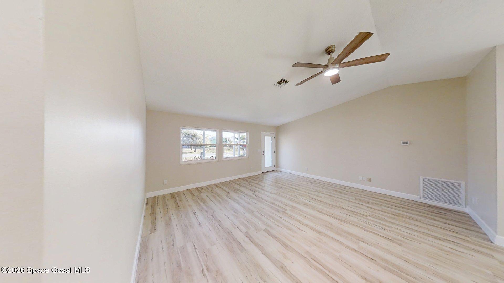 137 Concha Drive Sebastian, FL 32958 - Photo 4 of 29 a view of empty room with wooden floor and fan