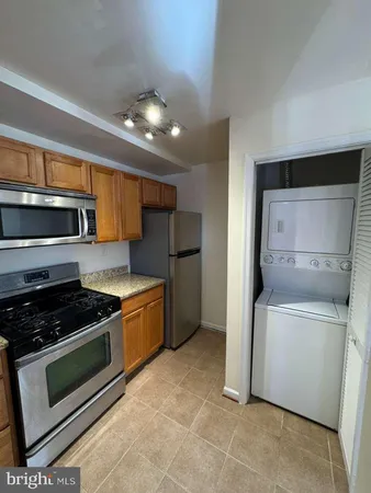 a kitchen with stainless steel appliances granite countertop a stove a microwave and a refrigerator