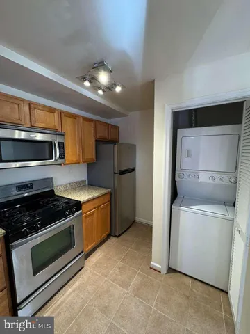 a kitchen with stainless steel appliances granite countertop a stove a microwave and a refrigerator