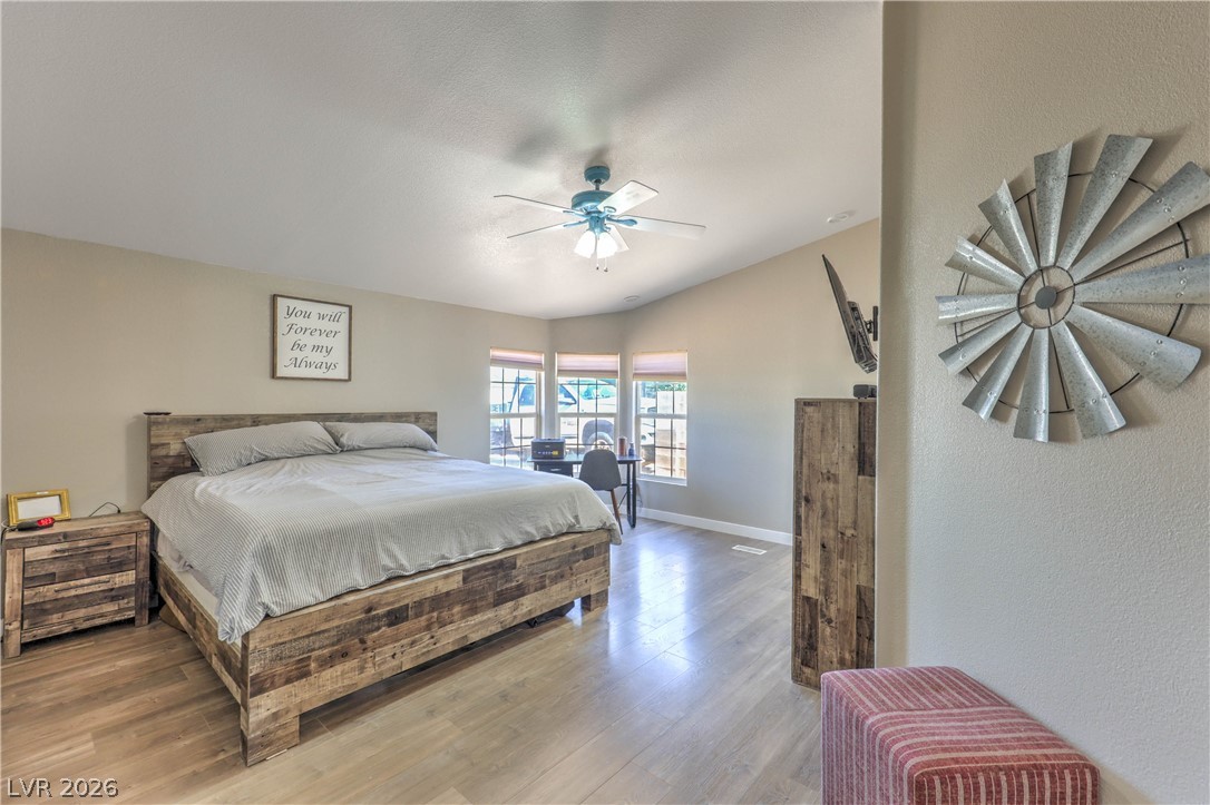 348 Tres Palomas Street Overton, NV 89040 - Photo 17 of 41 Natural light streams into this generously sized bedroom featuring high ceilings and modern wood flooring.