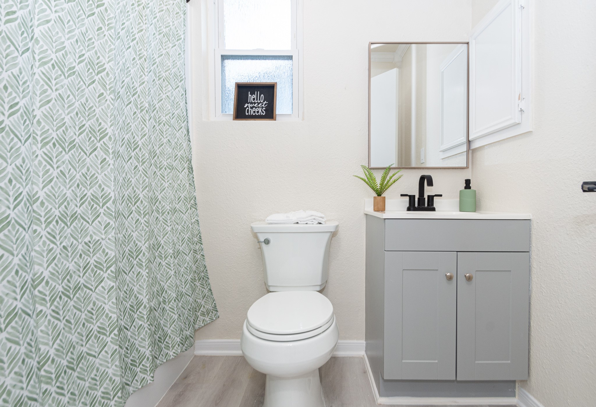 5834 Overdale Street Houston, TX 77033 - Photo 16 of 18 a bathroom with a toilet sink and mirror