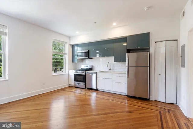 a kitchen with a refrigerator and a stove top oven