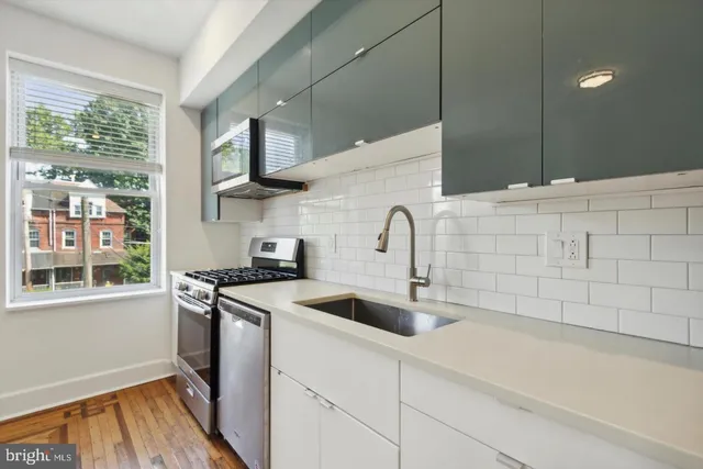 a kitchen with stainless steel appliances granite countertop a sink and a stove