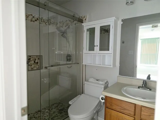 a bathroom with a granite countertop sink toilet and shower