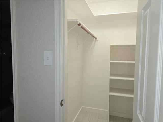 a view of walk in closet with empty racks