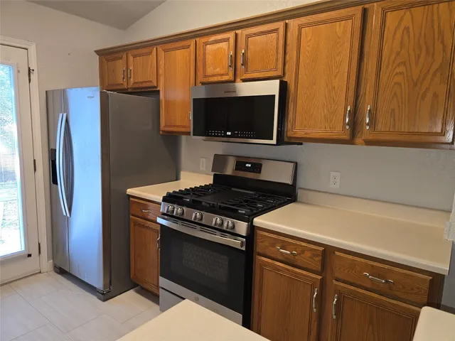 a kitchen with stainless steel appliances a refrigerator stove and microwave