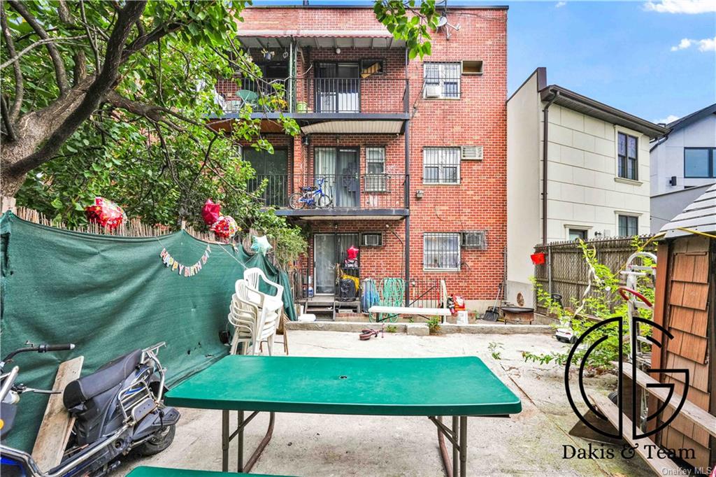 11-46 Welling Court Queens, NY 11102 - Photo 2 of 9 a building with table and chairs and potted plants