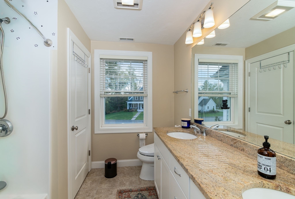 51 Tamarack Road Dracut, MA 01826 - Photo 22 of 39 a bathroom with a granite countertop sink a toilet a mirror and shower