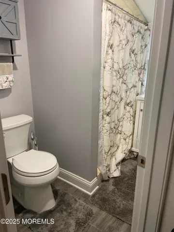 a bathroom with a toilet and a shower curtain