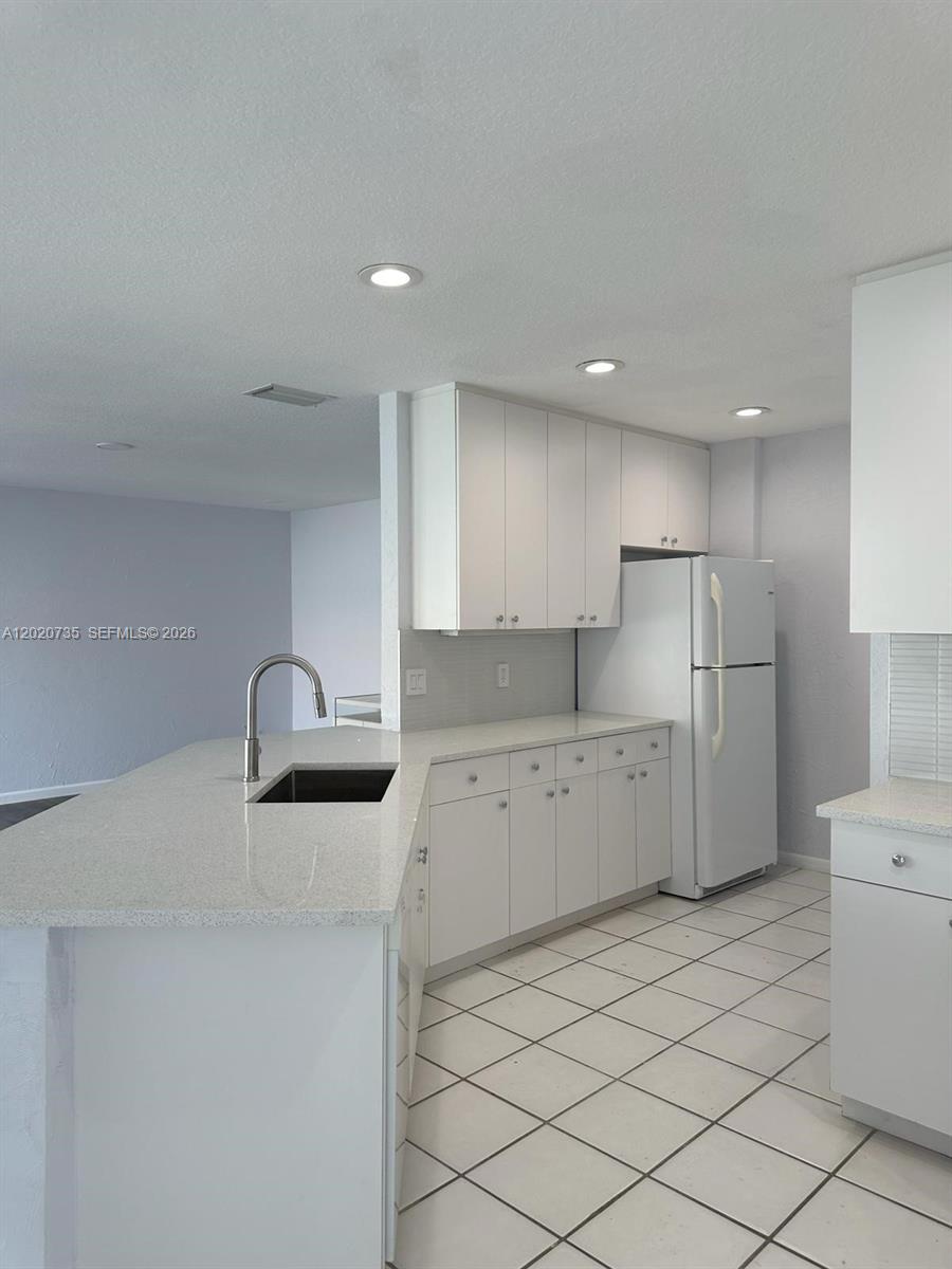 17244 Balboa Point Way Boca Raton, FL 33487 - Photo 18 of 66 a kitchen with a refrigerator sink and cabinets