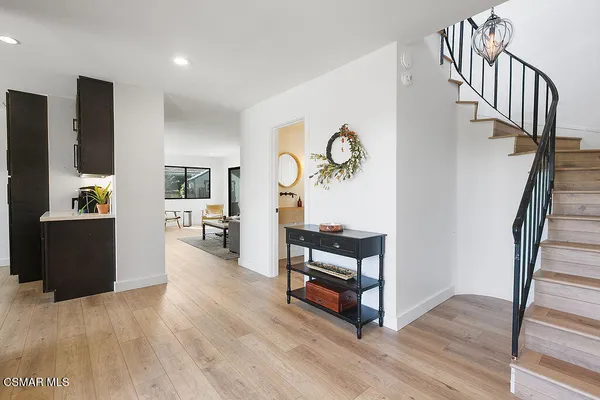 a view of a hallway with wooden floor and furniture
