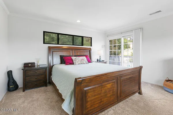 a bed sitting in a bedroom next to a window