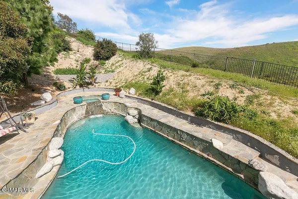 a view of a balcony with wooden chairs and city view