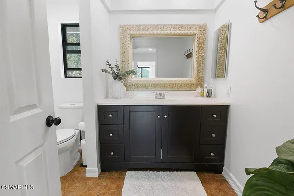 a bedroom with a bed and a dresser next to a window