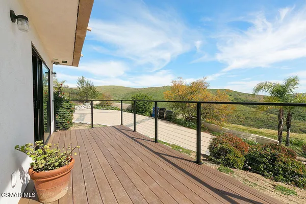 a view of balcony with wooden floor and fence