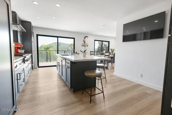 a open kitchen with stainless steel appliances granite countertop a stove and a wooden floors