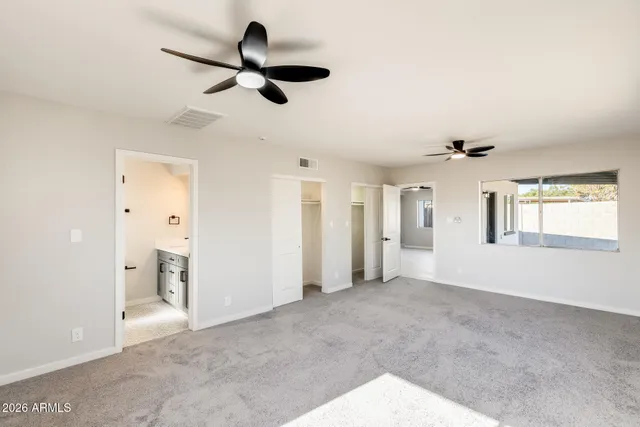 a view of an empty room and window and a ceiling fan