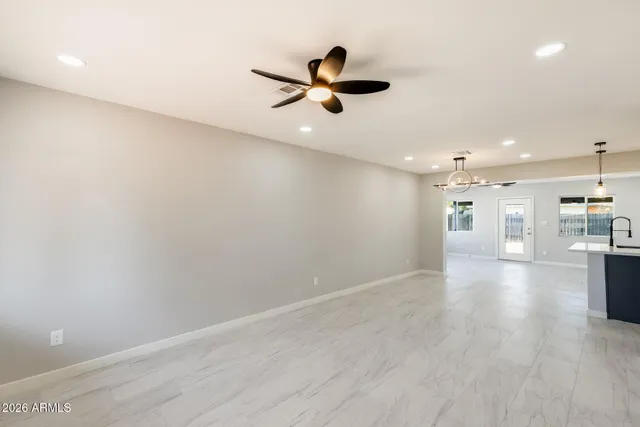 a view of empty room with wooden floor and windows