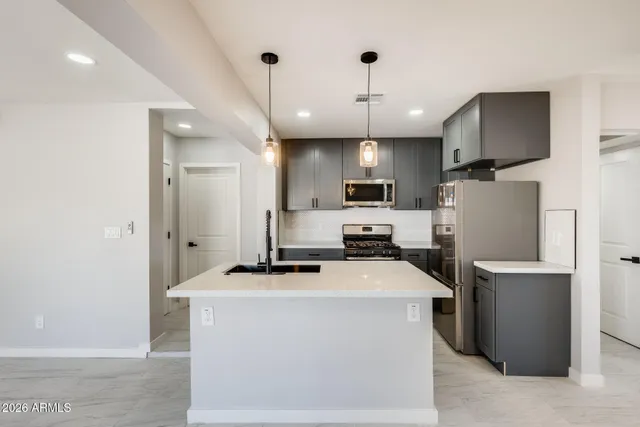 a kitchen with kitchen island a sink stainless steel appliances and counter space
