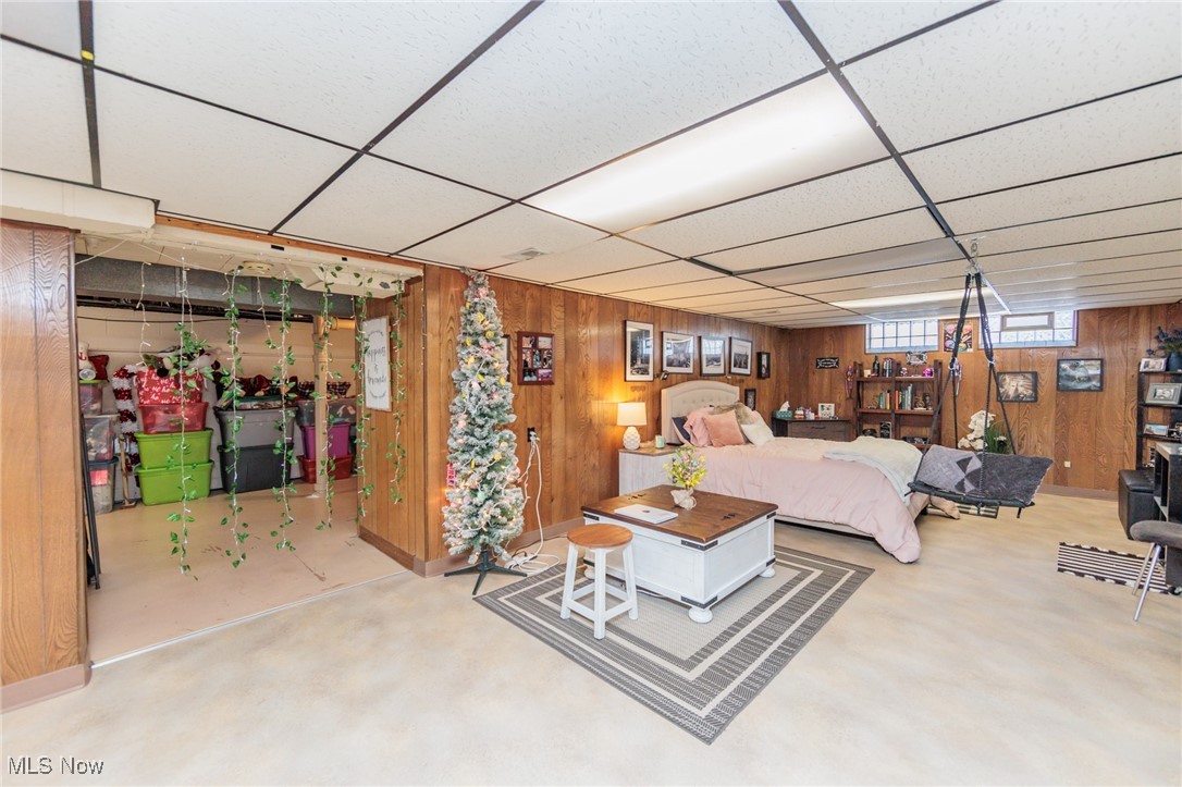 6901 Revere Road Cleveland, OH 44130 - Photo 35 of 50 Bedroom featuring carpet, a paneled ceiling, and wood walls