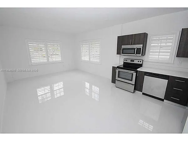 a living room with furniture a window and stainless steel appliances